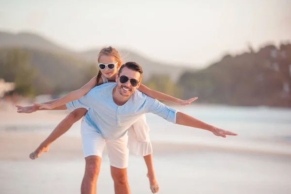 Klein meisje en gelukkig papa hebben plezier tijdens strand vakantie — Stockfoto