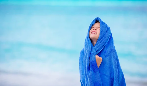 Очаровательная маленькая девочка, завернутая в полотенце на тропическом пляже после купания в море — стоковое фото