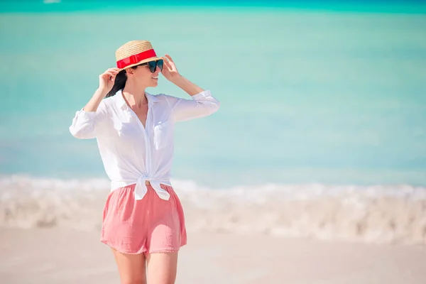 Joven mujer de moda en sombrero en la playa — Foto de Stock