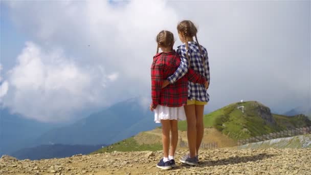 Meninas pequenas felizes bonitas em montanhas no fundo do nevoeiro — Vídeo de Stock