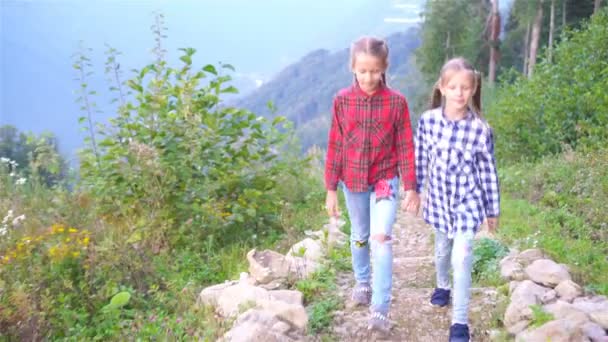 Gyönyörű boldog kislányok a hegyekben a köd hátterében — Stock videók