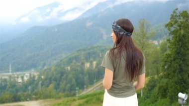 Sisin arkasındaki dağlarda güzel, mutlu genç bir kadın.