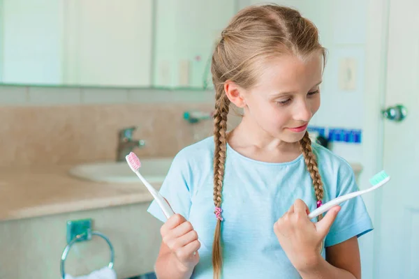 Kleines entzückendes Mädchen beim Zähneputzen im Badezimmer. perfektes schneeweißes Lächeln eines kleinen Mädchens — Stockfoto