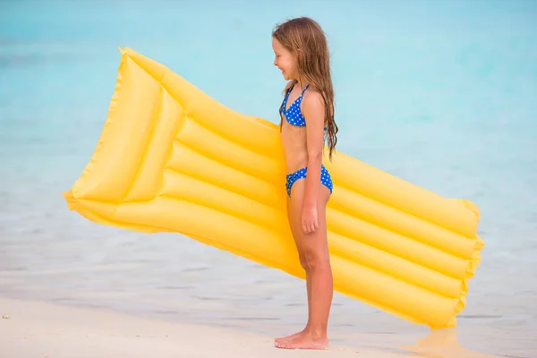 Schattig gelukkig meisje met opblaasbare lucht matras op witte strand — Stockfoto