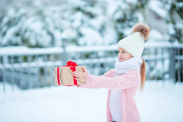 Adorable dziewczyna z prezent Boże Narodzenie box w zimie na zewnątrz na Boże Narodzenie — Zdjęcie stockowe