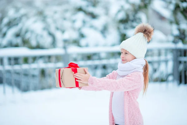 Adorable girl with christmas box gift in winter outdoors on Xmas eve — Stock Photo, Image