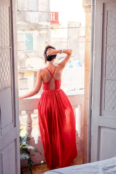 Joven mujer atractiva en vestido rojo en viejo balcón en apartamento en La Habana —  Fotos de Stock