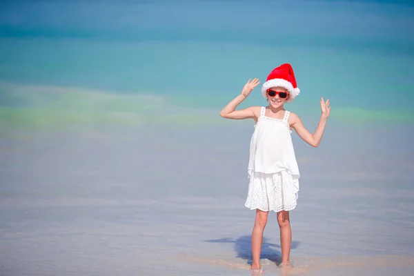 Adorable petite fille au chapeau de Père Noël sur la plage tropicale — Photo