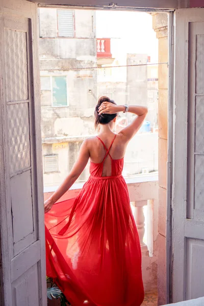 Young attractive woman in red dress on old balcony in apartment in Havana — Stock Photo, Image