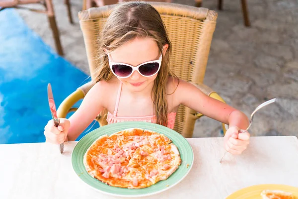 Malá holčička jíst pizzu na večeři — Stock fotografie