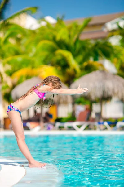 Маленькая активная симпатичная девочка в открытом бассейне готова плавать — стоковое фото