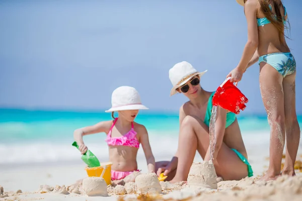 Família de mãe e filhos fazendo castelo de areia na praia tropical — Fotografia de Stock