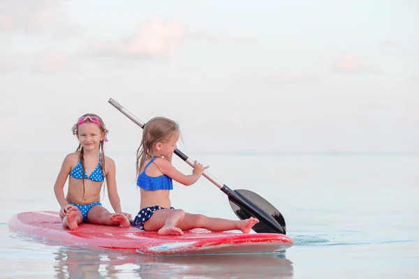 Niñas nadando en tabla de surf durante las vacaciones de verano —  Fotos de Stock