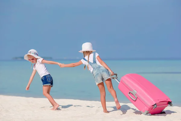 A trópusi fehér strand nagy bőrönddel, kislányok turisták — Stock Fotó