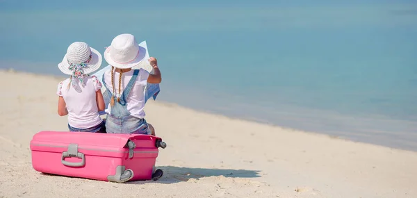 Pequeñas chicas turistas con gran maleta en la playa tropical blanca —  Fotos de Stock