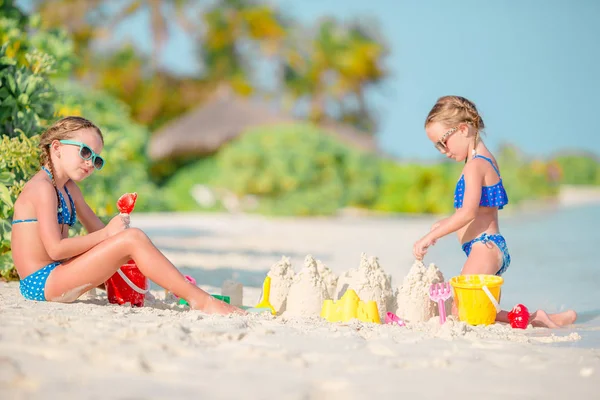 Two kids making sand castle and having fun at tropical beach — Stock Photo, Image