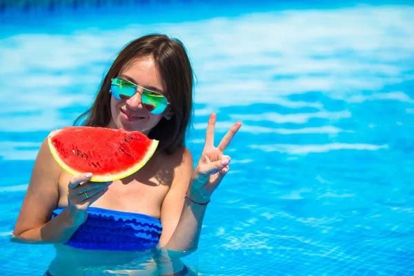 Joven chica feliz en gafas de sol con sandía relajante en la piscina — Foto de Stock