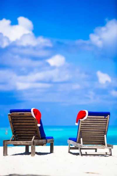 Kerstmis tropische concept: strand ligstoelen met rode Santa hoeden — Stockfoto