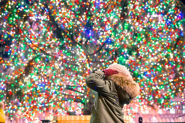 Chica feliz en el fondo del árbol de Navidad Rockefeller en Nueva York —  Fotos de Stock