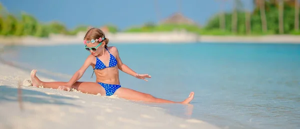 Очаровательная маленькая девочка во время пляжного отдыха развлекается — стоковое фото