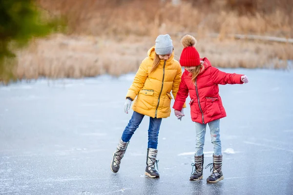 Adorable little girls skating on the ice-rink — Stock Photo, Image