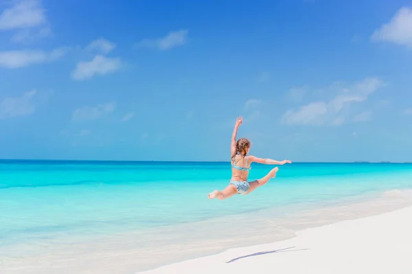 Chica activa en la playa divirtiéndose mucho en la orilla dando un salto —  Fotos de Stock