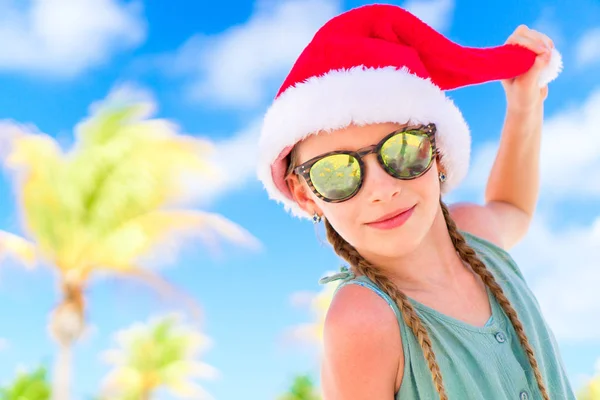 Portrait of little girl in Santa hat during Christmas beach vacation — Stock Photo, Image