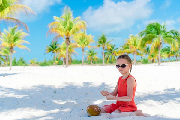 Rozkošná holčička s velkým kokosem na pláži — Stock fotografie