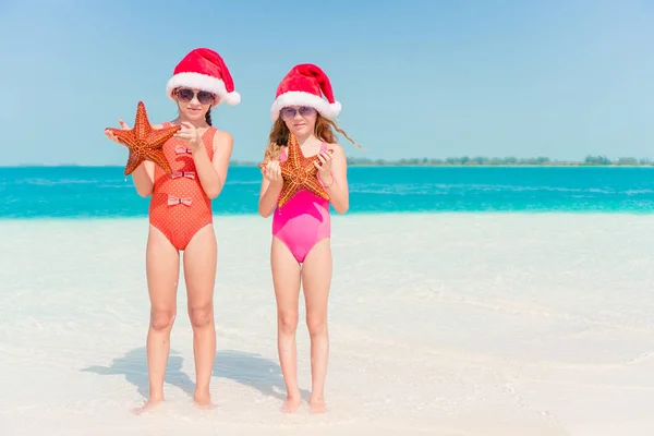 Adorable little girls on Christmas holidays on the beach — Stock Photo, Image