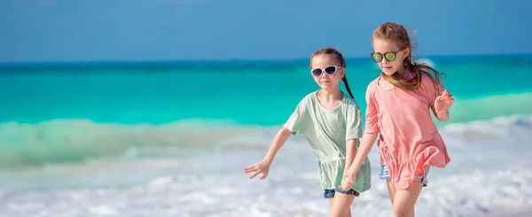 Pequenas crianças felizes se divertindo muito na praia tropical brincando juntas. Meninas adoráveis dançando na ilha do Caribe — Fotografia de Stock