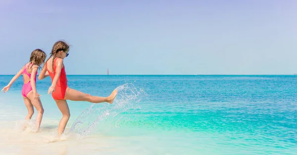 Meninas se divertindo na praia tropical jogando juntos em águas rasas — Fotografia de Stock