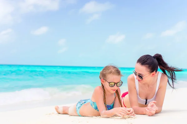 Pouco bonito menina e jovem mãe na praia tropical — Fotografia de Stock
