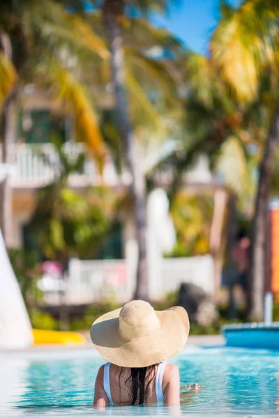 Vista trasera de la hermosa mujer joven relajándose en la piscina — Foto de Stock