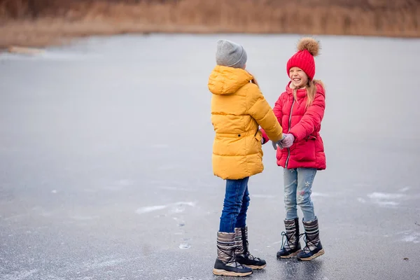 凍った湖の上で一緒に楽しんで愛らしい女の子 — ストック写真