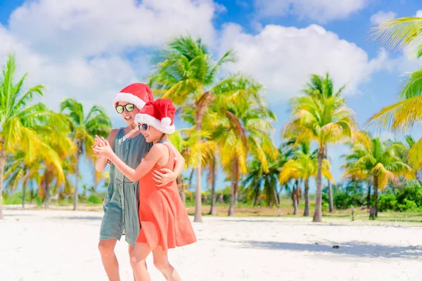 Little adorable girls in Santa hats during beach vacation have fun together — Stock Photo, Image