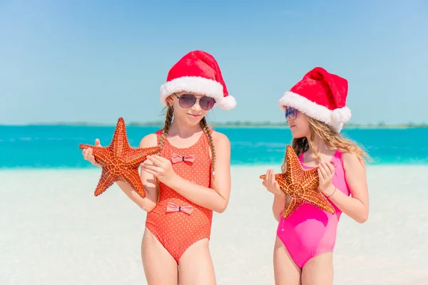 Adorable little girls on Christmas holidays on the beach — Stock Photo, Image