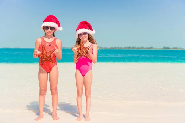 Adorable little girls on Christmas holidays on the beach — Stock Photo, Image