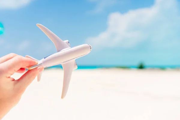 Petit avion jouet blanc sur fond de mer turquoise — Photo