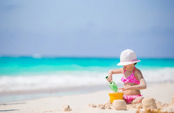 Bedårande liten flicka som leker med strandleksaker på den vita stranden — Stockfoto