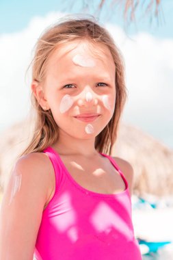 Babası kızı burun için güneş krem uygulamak.