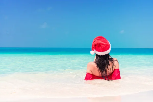 Młoda kobieta szczęśliwa w Santa hat w strój kąpielowy na plaży biały na Boże Narodzenie wakacje — Zdjęcie stockowe