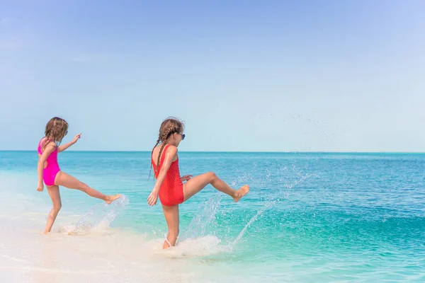 Dziewczynki, zabawy na tropikalnej plaży grając razem w płytkiej wodzie — Zdjęcie stockowe