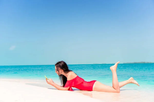 Ung kvinna på en tropisk strand med hatt — Stockfoto