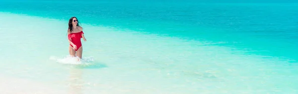Jovem menina bonita na praia em águas tropicais rasas — Fotografia de Stock
