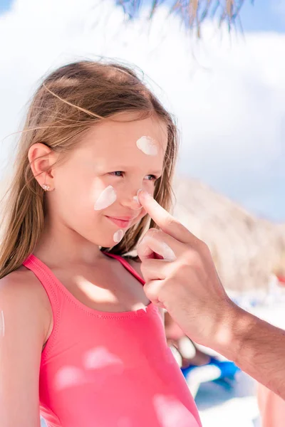 Vater cremt Tochter mit Sonnencreme ein. — Stockfoto