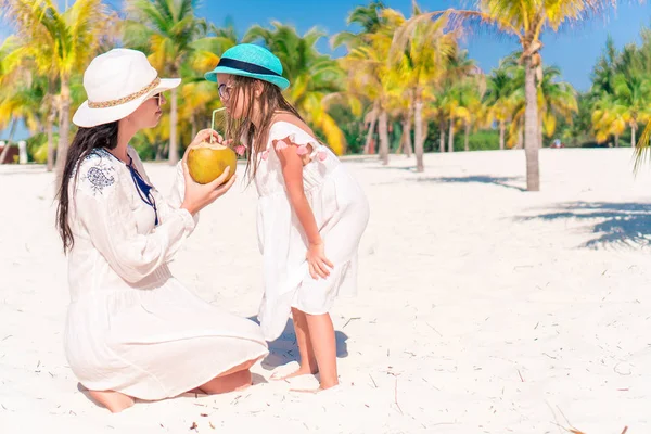 Petite fille et jeune mère au lait de coco sur une plage exotique — Photo