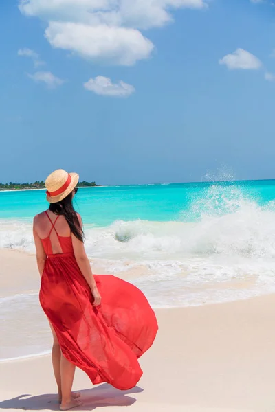 熱帯の海岸の赤いドレスの若い美しい女性 — ストック写真