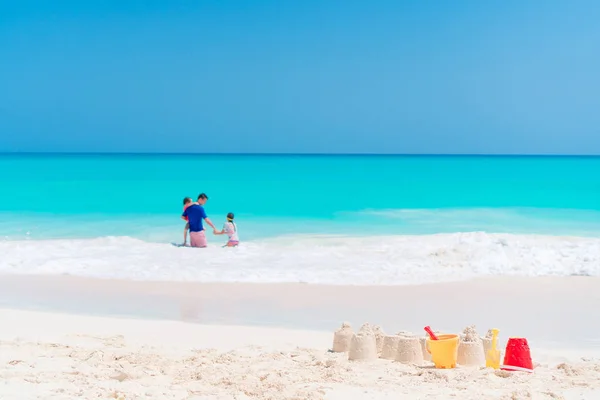 Sandburg am weißen Strand mit Plastikspielzeug — Stockfoto