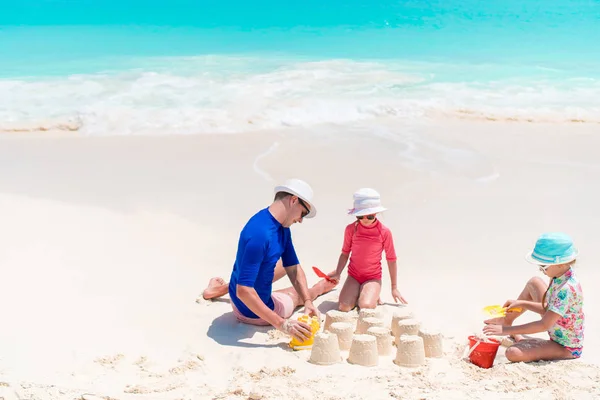 Baba ve küçük kızı tropikal sahilinde Kumdan kale yapma — Stok fotoğraf
