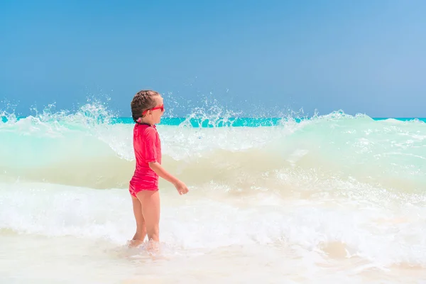 Adorable niña en la playa teniendo un montón de diversión en el agua —  Fotos de Stock